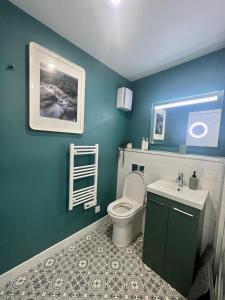 niebieska łazienka z toaletą i umywalką w obiekcie 16 Macgregor court, Oban w mieście Oban