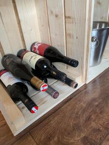 um grupo de garrafas de vinho numa caixa de madeira em Vinná maringotka em Slavonice