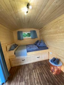 Ce lit se trouve dans une cabane en bois dotée d'une fenêtre. dans l'établissement Vinná maringotka, à Slavonice
