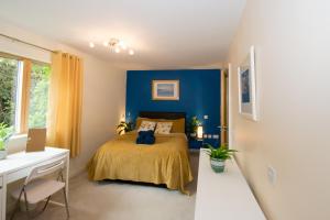 een slaapkamer met een bed met een blauwe muur bij Spacious 2 Beds & 2 Baths Flat at City Center in Birmingham