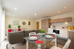 een keuken en een woonkamer met een tafel en stoelen bij Spacious 2 Beds & 2 Baths Flat at City Center in Birmingham