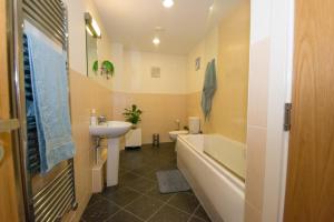 een badkamer met een wastafel, een bad en een toilet bij Spacious 2 Beds & 2 Baths Flat at City Center in Birmingham