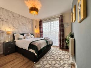 een slaapkamer met een bed en een kroonluchter bij Chelsea 2-Bedroom and Living Room Apartments in Londen