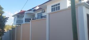 une clôture blanche devant une maison dans l'établissement Sami BnB - Apt 05 Makongo after Mlimani City, à Dar es Salaam