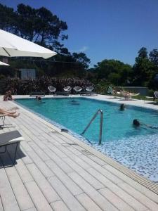 a swimming pool with people in the water at Torre Bellagio piso 14 Hermoso depto 3 personas in Punta del Este