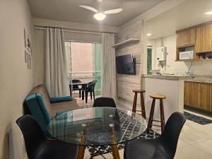 a living room with a glass table and chairs at AP encantador na Praia do Forte! Porto Azul (107) in Cabo Frio