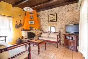 a living room with a couch and a tv at Samonas Traditional Villas in Samonás