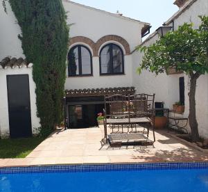 una casa con un banco junto a una piscina en El Palacete de Manuela en Ronda