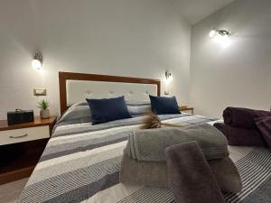 a bedroom with a large bed with blue pillows at Angela House in Teulada