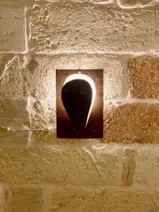 a light socket on a brick wall with a urinal at HABITARE Lecce & Salento in Lecce