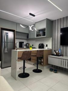 a kitchen with a counter and two bar stools at Studio Chácara Sto Antonio in Sao Paulo