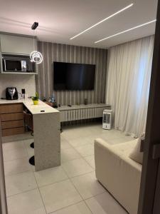 a living room with a couch and a tv at Studio Chácara Sto Antonio in Sao Paulo