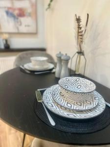 a black table with two plates and a knife and fork at Cosy Stylish Studio Apartment in Trowbridge