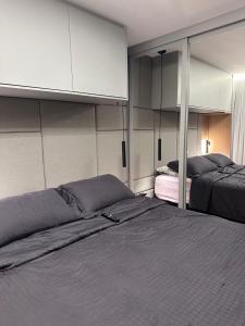 a bedroom with two beds and a cabinet at Studio Chácara Sto Antonio in Sao Paulo
