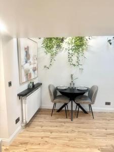 a dining room with a black table and chairs at Cosy Stylish Studio Apartment in Trowbridge