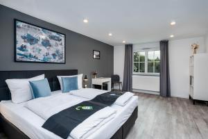 a bedroom with a large bed with blue pillows at Hotel Das Q Spaichingen in Spaichingen