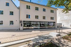 Un grand bâtiment blanc avec de nombreuses fenêtres dans l'établissement Hotel Das Q Spaichingen, à Spaichingen