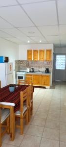 a kitchen with wooden cabinets and a table and a refrigerator at Departamento Navarro 2 in Malargüe