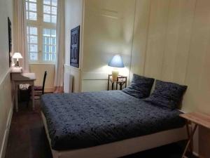 1 dormitorio con cama, escritorio y ventana en Appartement Intra-Muros - 2 chambres en Saint-Malo