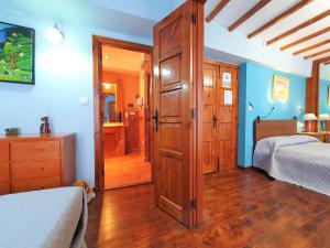 a bedroom with two beds and a large wooden door at Casa Bracamonte in Mondoñedo