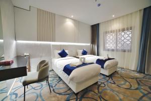 una camera d'albergo con 2 letti e una scrivania di فندق زوايا الماسية(العوالي) a Medina