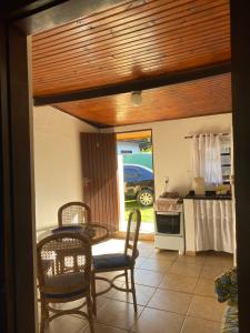 een eetkamer met een tafel en stoelen en een keuken bij Recanto Primavera in Boicucanga