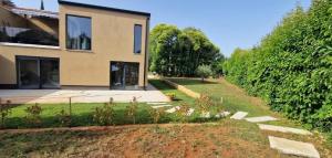 una casa con un jardín delante de ella en Apartman Oli 1, en Poreč