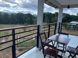 a porch with a table and chairs and a view of a field at Chácara Reserva do Cerrado in Cavalcante