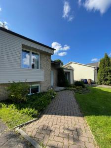 a house with a brick walkway in front of it at Beautiful Renovated House Laval in Laval