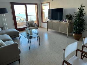un salon avec une télévision à écran plat et un canapé dans l'établissement APARTAMENTO CALAFLORES, à Cap de Palos