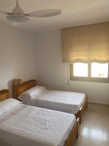 une chambre avec deux lits et une fenêtre dans l'établissement APARTAMENTO CALAFLORES, à Cap de Palos