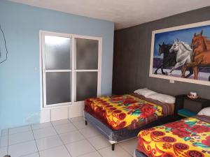 1 dormitorio con 2 camas y ventana en CASA EMILY en San Pedro La Laguna