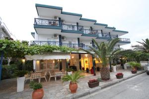 ein Gebäude mit einer Terrasse und Pflanzen davor in der Unterkunft Hotel Alexandros in Pori