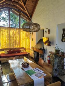 uma sala de estar com uma mesa e uma lareira em Cabañas Lelikelen em Villa La Angostura