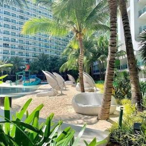 a resort with palm trees and a swimming pool at 1 Bedroom Unit with Massage Chair, Karaoke, Smart TV at Azure Urban Resort in Manila