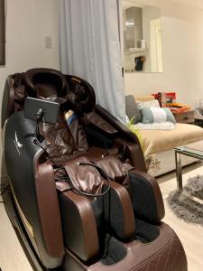 a brown leather reclining chair in a living room at 1 Bedroom Unit with Massage Chair, Karaoke, Smart TV at Azure Urban Resort in Manila