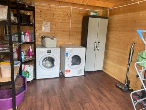 a laundry room with a refrigerator and a washing machine at Daisy Cabin in Kincardine OʼNeil