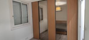 a hallway with a mirror and a door to a room at Le Pavillon Les BUISSONNETS in Salon-de-Provence