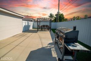 patio con griglia sul lato di una casa di Modern 6 bedroom home with Pool and BBQ in Miami L34 a Miami