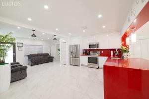 una cucina e un soggiorno con armadi rossi e bianchi di Modern 6 bedroom home with Pool and BBQ in Miami L34 a Miami