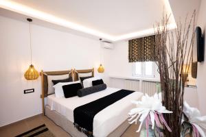 a bedroom with a bed with black and white pillows at Case di Venia in Agia Anna