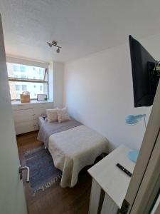 a small room with a bed and a television at Rocky House - Hostal Boutique Providencia in Santiago
