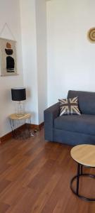 uma sala de estar com um sofá azul e uma mesa em L'Escapade Appartement T1 douillet tout confort em Roanne
