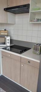 uma cozinha com uma placa de fogão e forno. em L'Escapade Appartement T1 douillet tout confort em Roanne