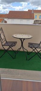 einen Tisch und zwei Stühle auf einem Balkon in der Unterkunft L'Escapade Appartement T1 douillet tout confort in Roanne
