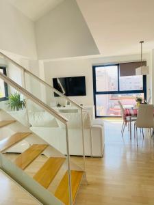 uma escada branca numa sala de estar com uma mesa em Habitaciones confort em Benetúser