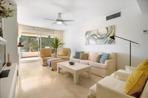 uma sala de estar com um sofá e uma mesa em Apartamento con espectaculares vistas al Golf en Marbella - Xallas 2 3 em Marbella