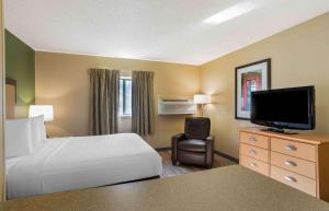 a hotel room with a bed and a flat screen tv at Brentwood Studioplus in Brentwood