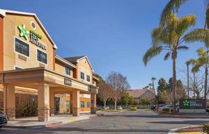 uma loja em frente a um hotel com uma palmeira em Extended Stay America Suites - Los Angeles - Long Beach Airport em Long Beach