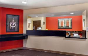 a waiting room with red walls and a reception counter at Extended Stay America Suites - Los Angeles - Long Beach Airport in Long Beach